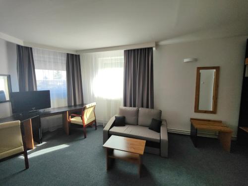 a living room with a couch and a desk at Hotel P7 in Lučenec