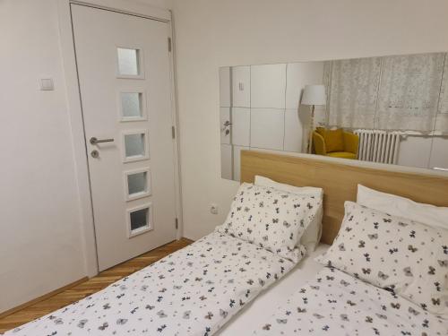 sypialnia z łóżkiem i lustrem w obiekcie Apartman Zlatovo Stan Na Dan w mieście Požarevac
