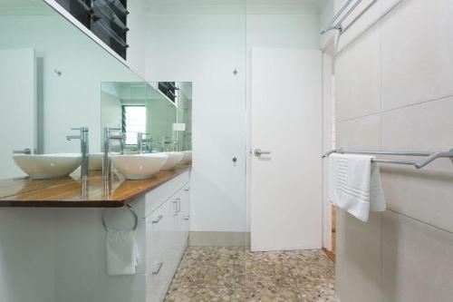 ein Badezimmer mit 2 Waschbecken und einem Spiegel in der Unterkunft Great Northern Beach House in Yorkeys Knob