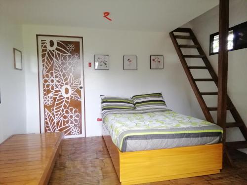 a bedroom with a bed next to a staircase at Uphill Cozy Cabins in an Island Lake for Family getaway in Cavinti