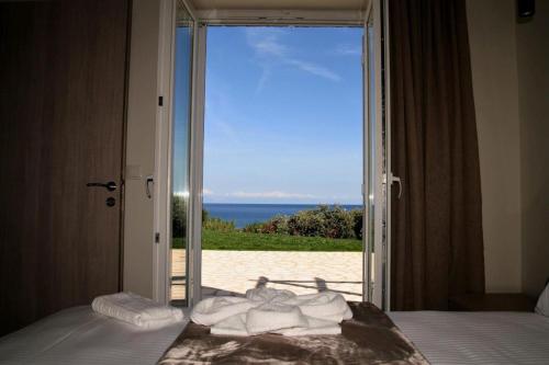 a bedroom with a door open to a view of the beach at Stone Bay Houses in Messinia Kalamaki Beach Area in Chrani