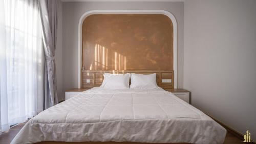 a bedroom with a bed with a large painting on the wall at JB. Nguyễn Villa NovaWorld Phan Thiết in Phan Thiet