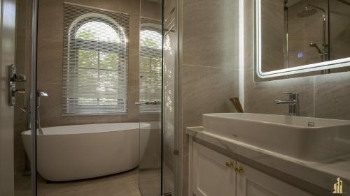a bathroom with a tub and a sink and a bath tub at JB. Nguyễn Villa NovaWorld Phan Thiết in Phan Thiet