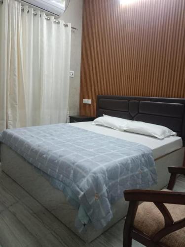Preet Home Stay في فاراناسي: غرفة نوم بسرير كبير مع بطانية زرقاء