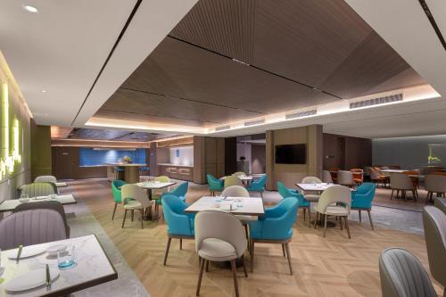 a dining room with tables and chairs at Holiday Inn Express Shanghai Gumei by IHG in Shanghai