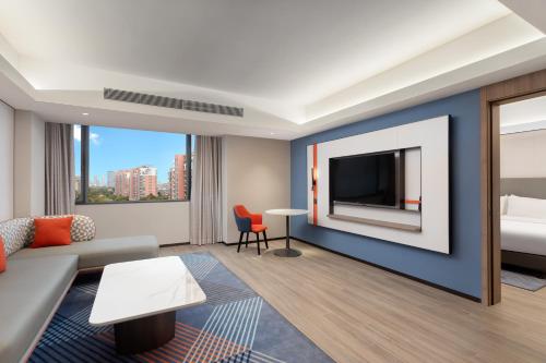 a living room with a couch and a tv at Holiday Inn Express Shanghai Gumei, an IHG Hotel in Shanghai
