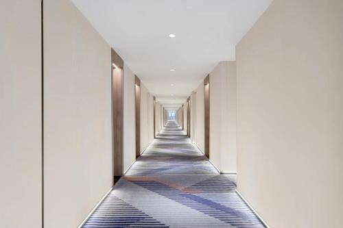a corridor of a building with a long hallway at Holiday Inn Express Shanghai Gumei by IHG in Shanghai