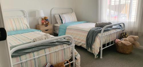 a bedroom with two beds and a window at Ballarat Holiday Homes - Hopetoun Cottage - Minutes from Ballarat CBD - Sleeps 1 to 6 in Ballarat