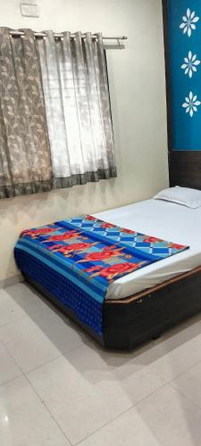a bed sitting on a floor in a room at Hotel sai vasant vihar in Shirdi