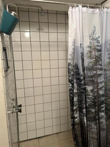 a shower with a shower curtain in a bathroom at Hestra Guesthouse in Hestra