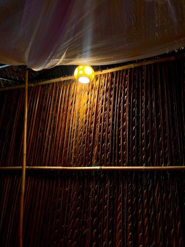 a light in a room with a wooden wall at Hometravel Mekong Can Tho in Can Tho