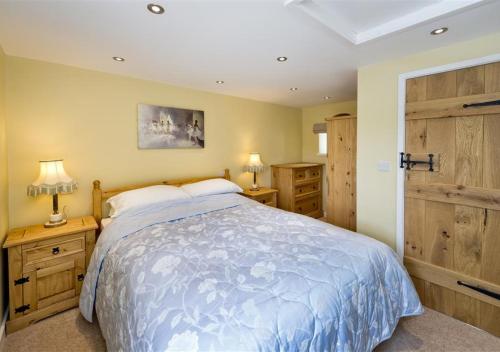 LlanenganにあるBryn Refail Bachのベッドルーム1室(ベッド1台、ナイトスタンド2つ、ランプ2つ付)