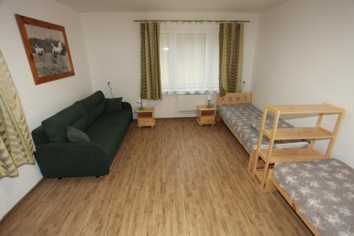 a living room with a green couch and a table at Leśniczówka Wigierskiego Parku Narodowego w Maćkowej Rudzie in Krasnopol