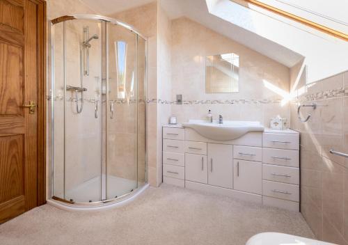 a bathroom with a shower and a sink at Llecyn in Pwllheli