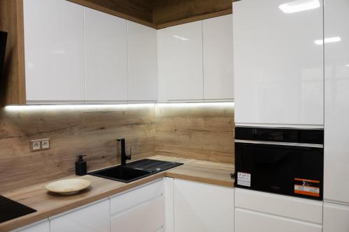 a white kitchen with a sink and a microwave at Ubytování v Beskydech - Apartmán Patrik in Čeladná