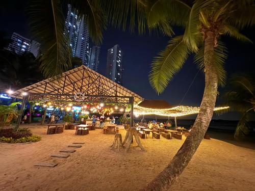 a restaurant on a beach at night with a palm tree at Muji Full Seaview FOC Netflix 2CarPark 3BR 6-12pax in Johor Bahru