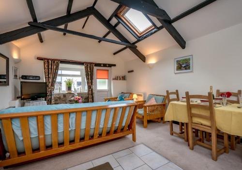 a living room with a table and a dining room at Camellia Cottage in Llanbedrog