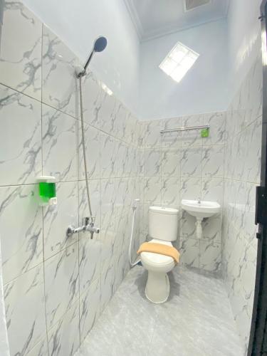 a bathroom with a toilet and a sink at Ayuri Hotel Malioboro in Sentool