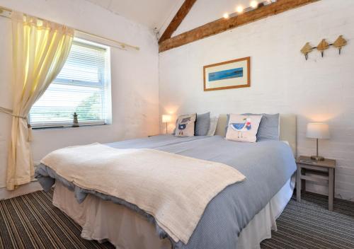 a bedroom with a bed and a window at Y Stabl in Abersoch