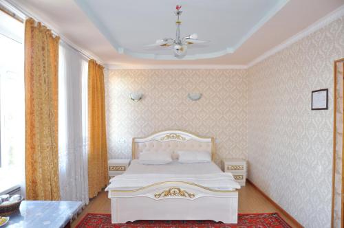 a bedroom with a white bed in a room at Шинам Мехмонхонаси in Eshonguzar