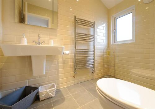 uma casa de banho com um lavatório, um WC e uma banheira em Lluesta Cottage em Abersoch
