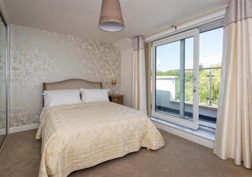 a bedroom with a bed and a large window at 8 Tai Dyffryn in Abersoch