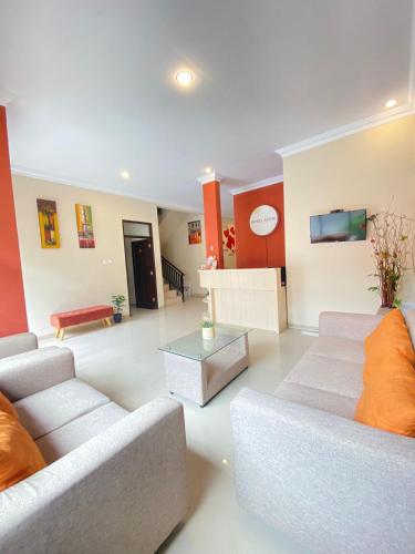 a living room with two couches and a table at Ayuri Hotel Malioboro in Sentool