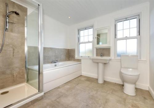 a bathroom with a toilet and a sink and a shower at Wendon in Abersoch