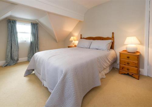 a bedroom with a white bed and a window at Wendon in Abersoch