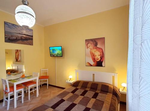 ein Schlafzimmer mit einem Bett und einem Tisch sowie ein Esszimmer in der Unterkunft La Casetta di Maria in Lido di Venezia