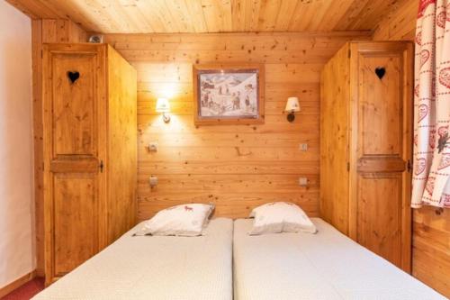 a bedroom with a bed in a wooden room at CASA-Chalet Brizolée lake-view chalet in Tignes close to ski area in Tignes