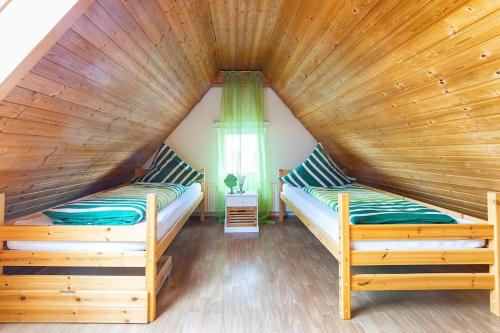 メミンゲンにあるAlpen-Hostel Apartment Südgrat mit Motorradvermietungの木製天井のドミトリールームのベッド2台分です。