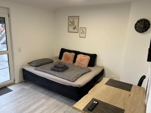 a small bedroom with a bed and a table at Kirchdorf Lounge - komplette Ferienwohnung in Unteropfingen