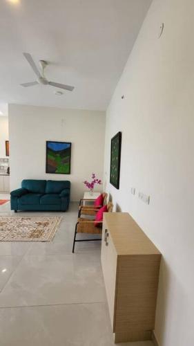 a living room with a blue couch and a table at Lucky Charm 2BHK Apartment - Muttukadu ECR in Chennai