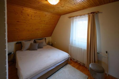- une chambre avec un lit blanc et une fenêtre dans l'établissement Szilvia Jakuzzis Vendégház Szarvas, à Szarvas