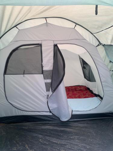 a white tent with the door open on the ground at Tiu Ronton River , Bungalows Camping and Trekking in Pawenang