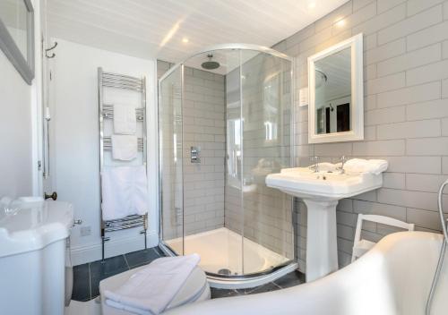uma casa de banho com um chuveiro, um lavatório e um WC. em Suffolk Cottage em Porthleven