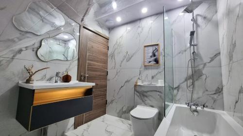 a bathroom with a toilet and a sink and a shower at Top floor apartment in central Buxton in Buxton