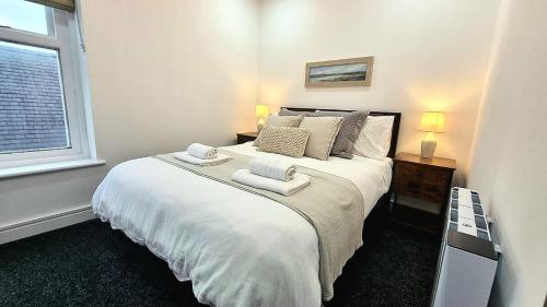 a bedroom with a large bed with towels on it at Top floor apartment in central Buxton in Buxton