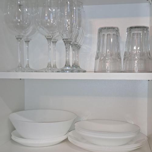 a row of wine glasses and a bowl on a shelf at MHL Apartament Lublin in Lublin
