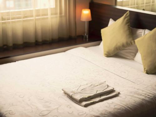 ein weißes Bett mit einem Tablett mit Handtüchern darauf in der Unterkunft Hotel Brighton City Osaka Kitahama in Osaka