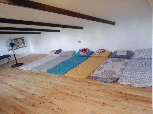 two beds in a room with a wooden floor at Cozy Lake House Accommodation for 10 to 15 guests 