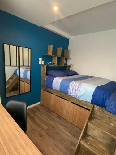 une chambre avec un lit, un miroir et une table dans l'établissement Studio neuf à Bouguenais+terrasse+parking, à Bouguenais