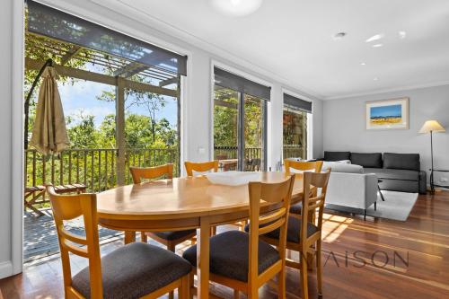 a dining room and living room with a table and chairs at Two Bedroom Villa in The Hunter Valley in Pokolbin