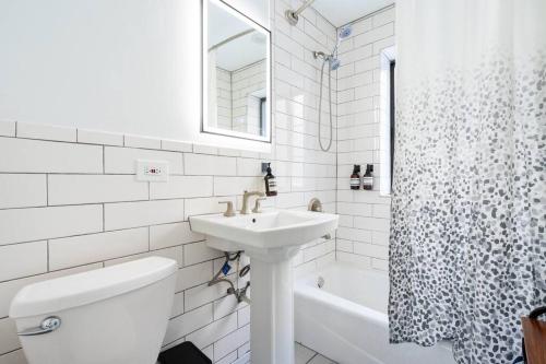 a white bathroom with a sink and a toilet at Apartment by the lake in Chicago