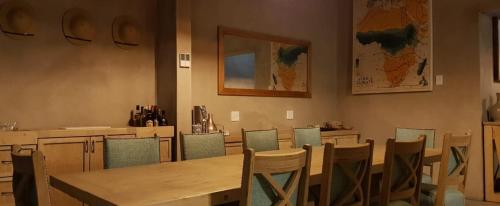 a dining room with a wooden table and chairs at Dream of Africa Bush Lodge in Marloth Park
