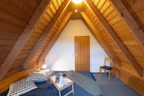 a bedroom in an attic with a bed and a table at LA 26 - Strandvogt 3 Komfort in Schottwarden