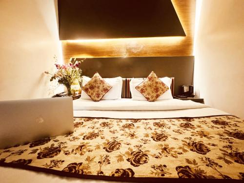 Hotel Jai Balaji Near New Delhi Railway Station في نيودلهي: غرفة في الفندق مع سرير مع لاب توب عليه