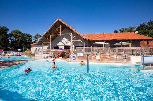 grupa ludzi pływających w basenie w obiekcie MH camping 4 étoile Mer/forêt w mieście Soulac-sur-Mer