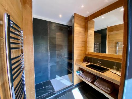 a bathroom with a glass shower and a sink at Côté Baie in Saint-Valery-sur-Somme